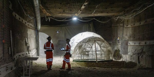 Two researchers flying a drone in one of the underground tunnels